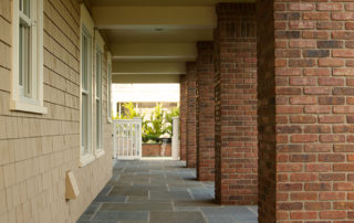 A walkway with brick walls and stone floors.