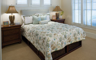 A bed with a floral bedspread and pillows.