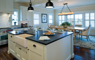 A kitchen with black counter tops and white cabinets.