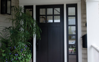A black door and white trim on the front of a house.