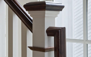 A wooden handrail on the side of a staircase.