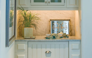 A white cabinet with drawers and a mirror above it.