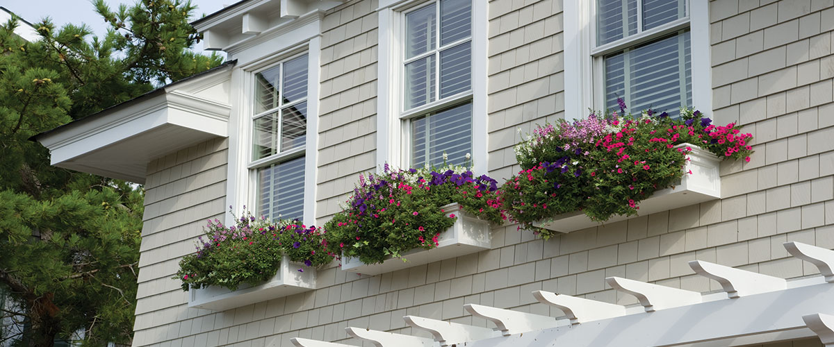 A building with three windows and flower boxes on the outside.