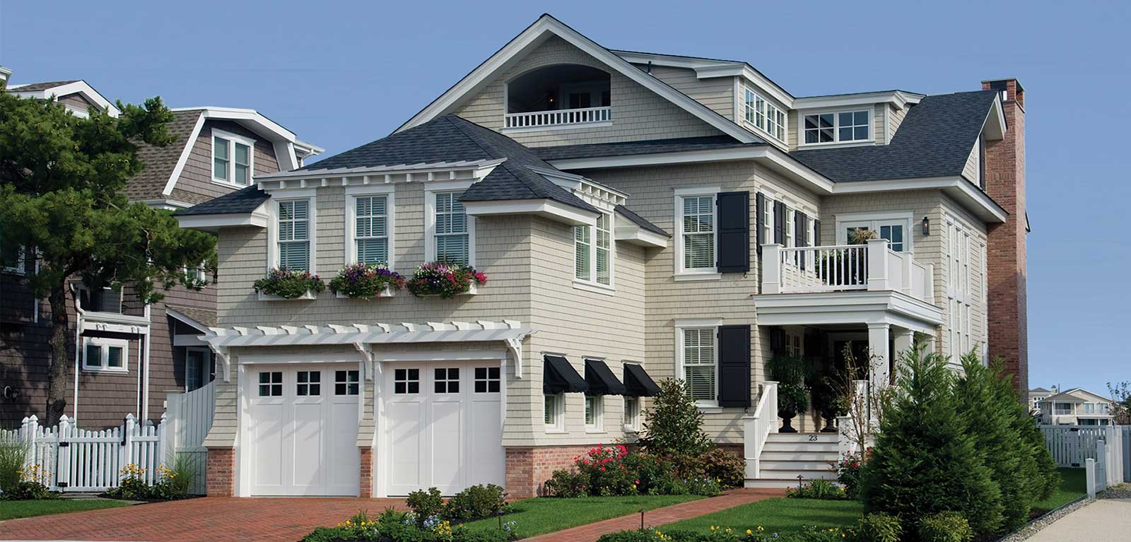 A large white house with two garage doors.