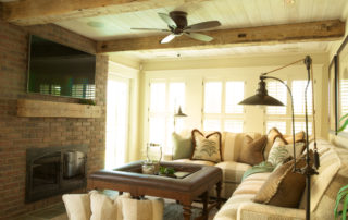 A living room with couches, table and ceiling fan.