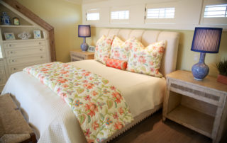 A bed with floral pillows and blankets on it.