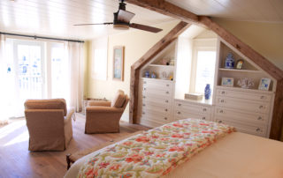 A bedroom with a bed, dresser and chair.