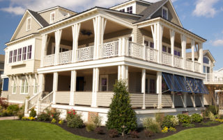 A large white house with a balcony and a porch.