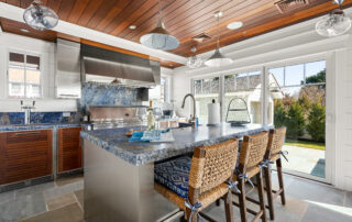 A kitchen with stainless steel counters and wooden ceiling.