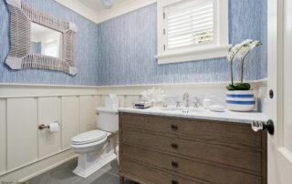 A bathroom with blue walls and white fixtures.