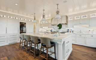 A large kitchen with white cabinets and island.