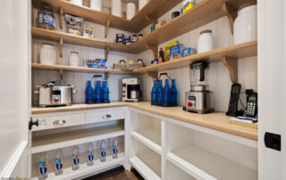 A kitchen with many shelves and cupboards filled with food.