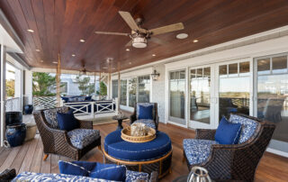 A patio with blue furniture and a ceiling fan.