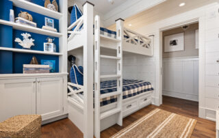 A bedroom with bunk beds and built in shelves.