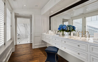 A bathroom with a large mirror and a blue stool