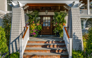 A front door with flowers on the steps.