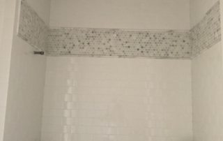 A bathroom with white walls and tiled ceiling.