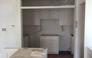 A kitchen with white walls and cabinets in it.