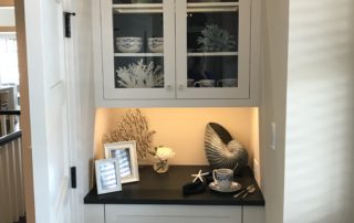 A white cabinet with glass doors and drawers.