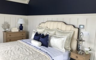 A bedroom with a bed, nightstand and lamps.