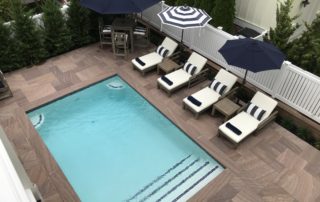 A pool with chairs and umbrellas next to it