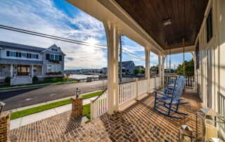 A porch with rocking chairs and a view of the water.