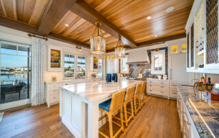 A large kitchen with wooden floors and white cabinets.