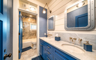 A bathroom with blue cabinets and white walls.