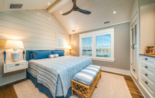 A bedroom with a bed, window and ceiling fan.