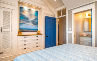 A bedroom with a blue door and white walls.