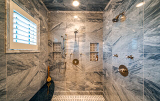 A large walk in shower with marble walls and floor.